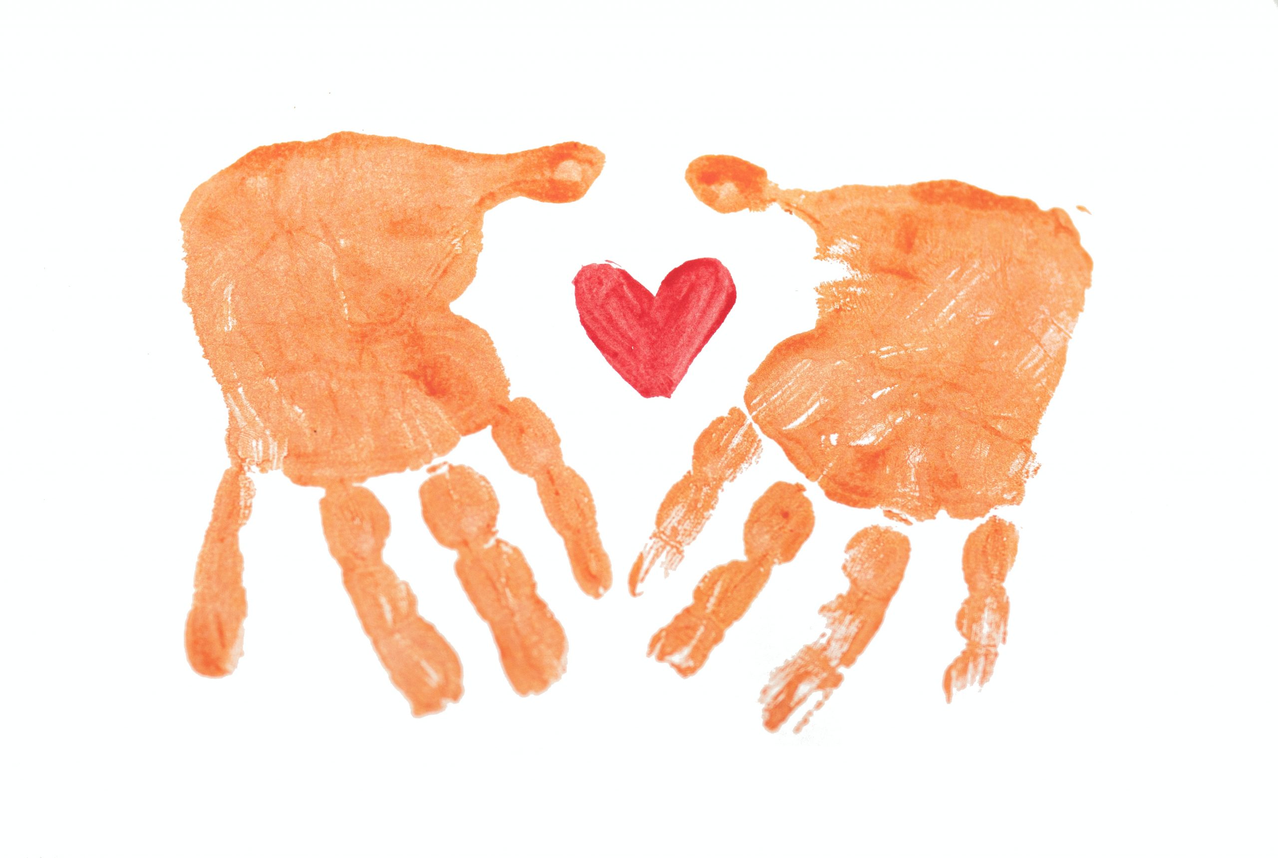 Desenho com pintura da palma de duas mãos de criança e um coração no meio.